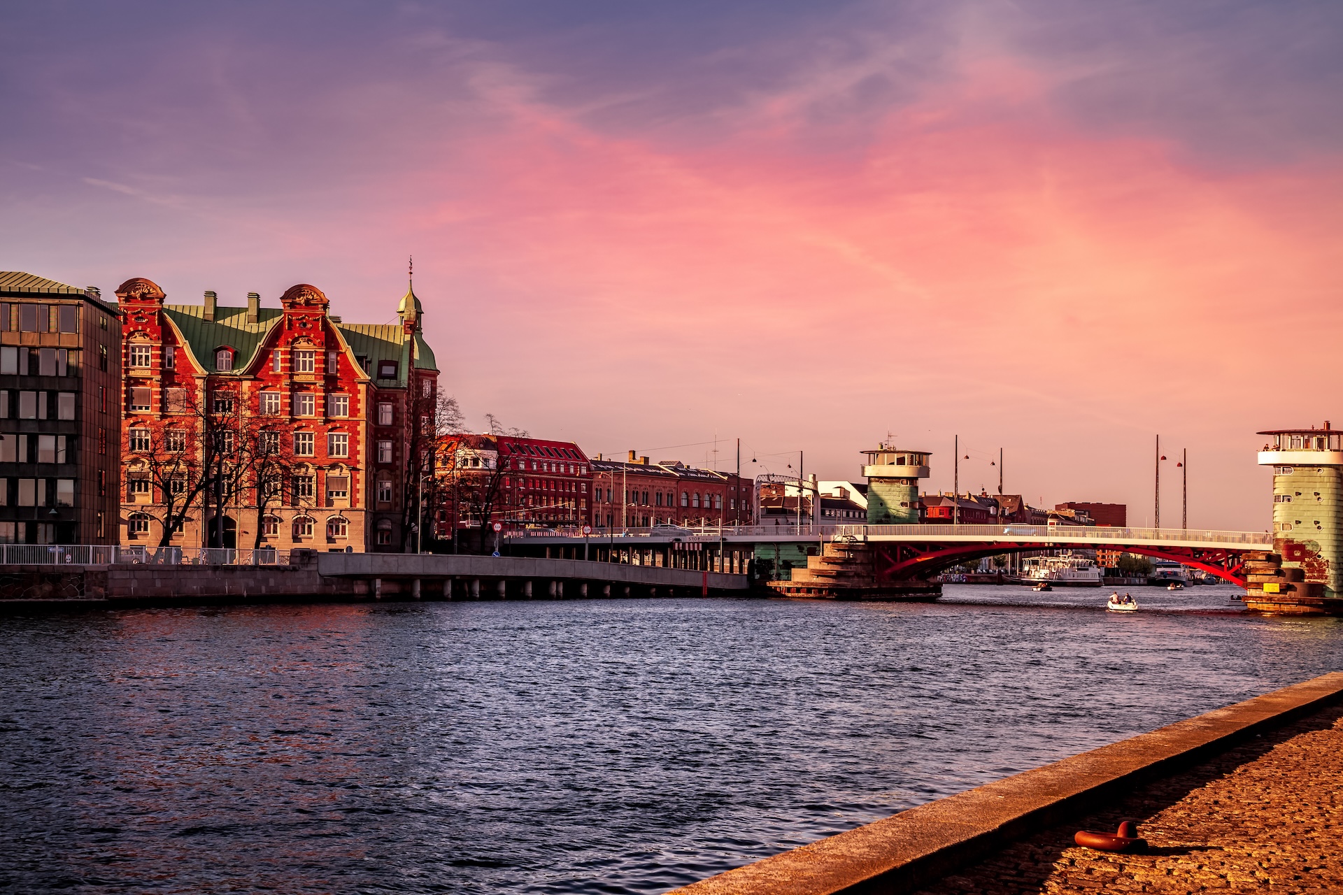 COPENHAGEN, DENMARK - MAY 6, 2018: scenic view of cityscape with river and bridge in foreground Luxury Limousine Services in Copenhagen by Nordic Limousine